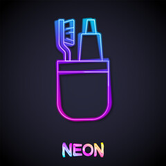 Glowing neon line Toothbrush and tube of toothpaste icon isolated on black background. Disposable bathroom supplies. Vector