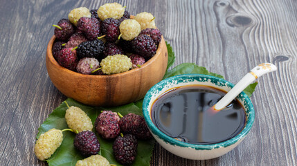 Domestic fresh mulberry molasses on a rustic wooden board