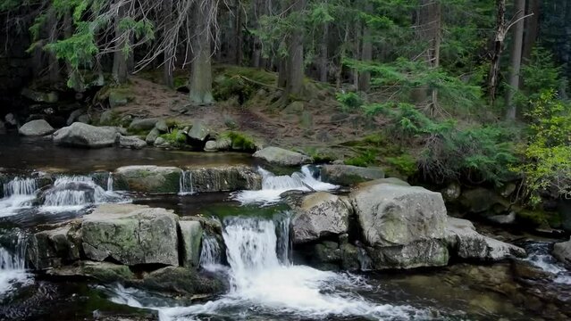 Mountain waterfalls with the rocks in the forest, zoom in, slow motion, wide shot, hd. ProRes 422 HQ.