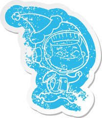 happy cartoon distressed sticker of a astronaut wearing santa hat