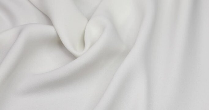 White fabric background. White cloth waves background texture. White fabric cloth textile material.