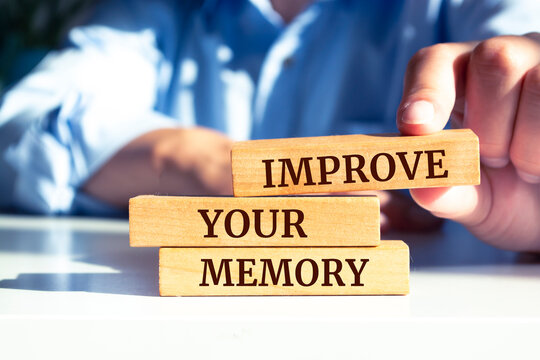Close up on businessman holding a wooden block with "Improve Your Memory" message