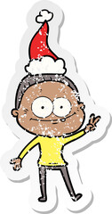 distressed sticker cartoon of a happy old woman wearing santa hat