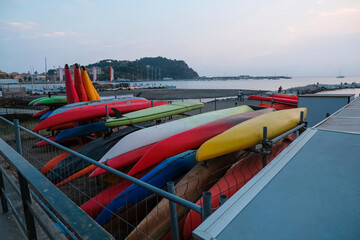 colorful kayak on the beach across the coastline and sunset sea in Sestri Levante, Liguria, Italy. Sea sport, active lifestyle