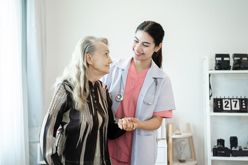 Fototapeta premium Professional helpful caregiver comforting senior woman at nursing home,Senior services and geriatric care concept.