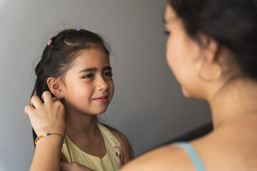 mother caresses her girl's face while they both smile