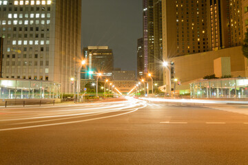 夜の都会の交差点と車のライトの軌跡