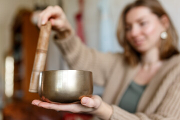 Young woman playing on a singing tibetian bowl.Relaxation and meditation.Sound therapy,alternative...