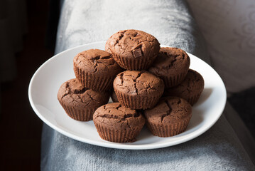 un bel piatto ricco di muffin al cioccolato appena sfornati, muffin al cacao con gocce di cioccolato