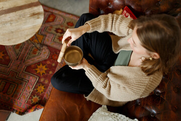 Young woman playing on a singing tibetian bowl.Relaxation and meditation.Sound therapy,alternative...