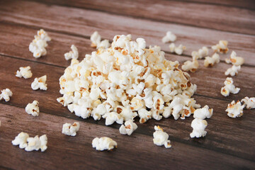 White fried popcorn on a brown wooden background
