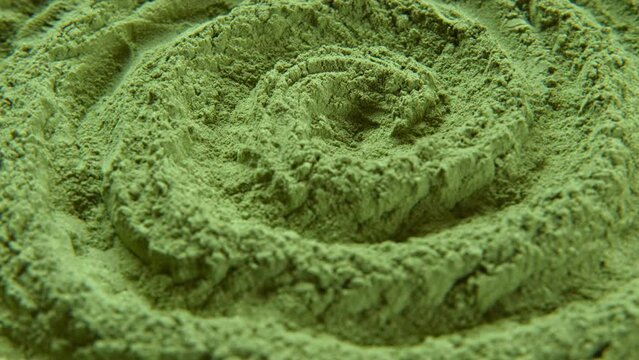 Chlorella or spirulina algae green powder is spinning, rotation. Dietary supplement to improve health. Seaweed superfood. Healthy food background. Vitamins and minerals to diet. Detox. Close up video.