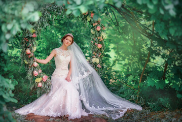 Fototapeta premium Wedding day. Holiday. Beautiful bride. Bride portrait. Beautiful wedding dress. Outside registration. Bride in a long veil. diadem. Summer wedding. Beautiful wedding decorations. Tenderness.Love.swing
