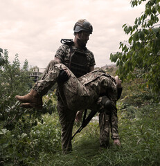 The commander carries a wounded soldier