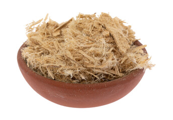 Small bowl filled with shredded slippery elm bark isolated on a white background side view. - 584308445
