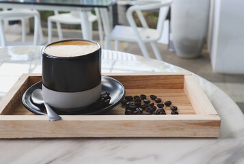 Coffee Cup and Beans on Wooden tray in coffee shop.