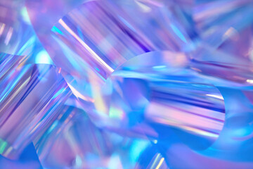 Close-up of ethereal pastel neon blue, purple, pink, mint holographic metallic foil background....