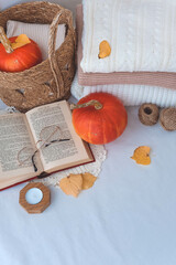 Autumn composition with pumpkins, knitted sweaters and book on white background