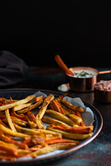 Healthy homemade oven baked sweet potato and carrot fries served with yogurt and green onion sauce. Low calorie vegetarian snack