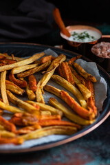 Healthy homemade oven baked sweet potato and carrot fries served with yogurt and green onion sauce. Low calorie vegetarian snack
