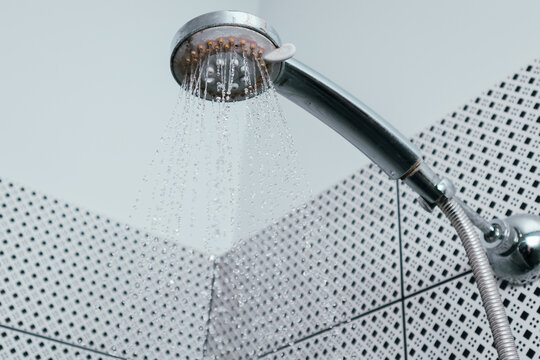 Silver shower head with limescales. Shower damaged from water scale.