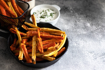 Healthy homemade oven baked sweet potato and carrot fries served with yogurt and green onion sauce. Low calorie vegetarian snack