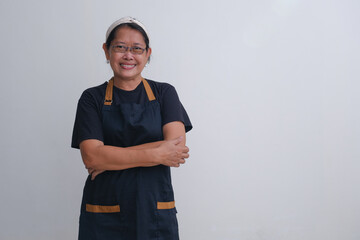 A woman wearing a black t-shirt and black apron, ready to work. Friendly and happy expression.