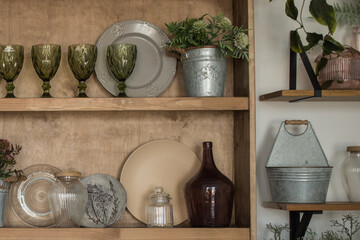 Wooden shelves, ceramic dishes, cutlery, decorations in the kitchen in a boho or rustic style....