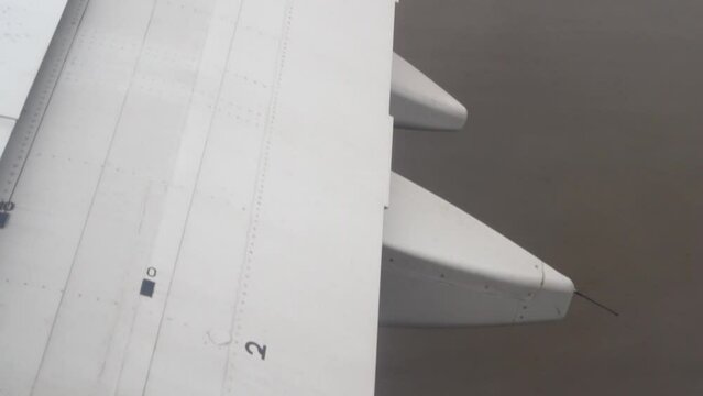 Acceleration and takeoff of the aircraft from the runway, view from the porthole on part of the lowering, increasing curvature of the vibrating wing.