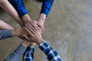 Stack of hands showing unity and teamwork. Group of friends put their hands together with copy space.