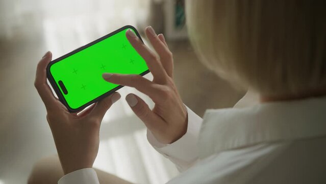 Hand scrolling on horizontal green screen smartphone