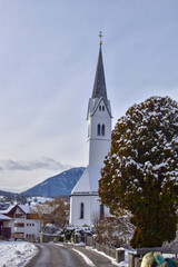 Panoramic view of beautiful winter wonderland mountain scenery in the Alps with pilgrimage church of Maria Gern