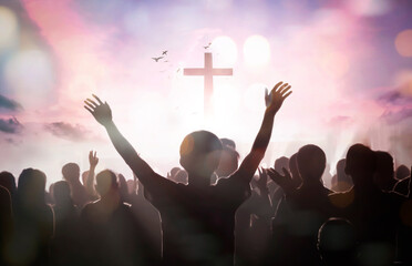 Easter and Good Friday concept, Silhouette many people raised hands worship god over sunset cross...
