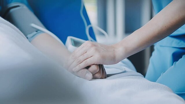 Doctor giving hope. Close up shot of young female physician leaning forward to smiling elderly lady patient holding her hand in palms. Woman caretaker in white coat supporting encouraging old person