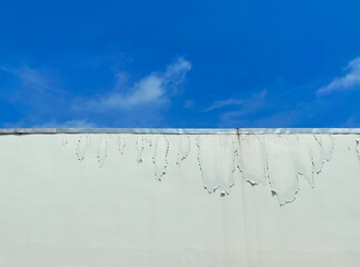 The walls are pale, peeling off due to poor quality paint and being weathered by bad weather.