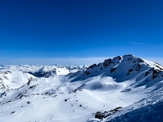 Alpine valley, snowy mountains in Switzerland. Panoramic view over the mountains during winter. Ski...
