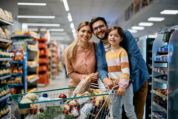 Happy family buying supermarket and looking at camera.