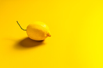 Eine ganze Zitrone auf einem gelben Hintergrund. Monochrom.