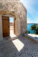 sunlight falls through an open castle door in sibenik in croatia on the side you can see the adriatic sea