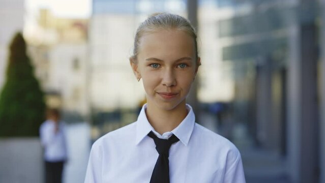 Portrait of the Beautiful Little Businesswoman in Formal Suite Standing near Office Centre. Kid Employee near the Work Space, Looking at the Camera. Girl after School. Pupil Portrait