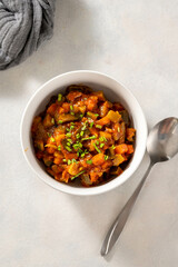 Vegetable stew, vegan healthy food in white bowl. Top view.
