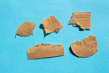 Set of ripped cardboard pieces on a blue background