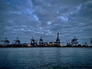 Port at dusk with cargo, ship and cranes