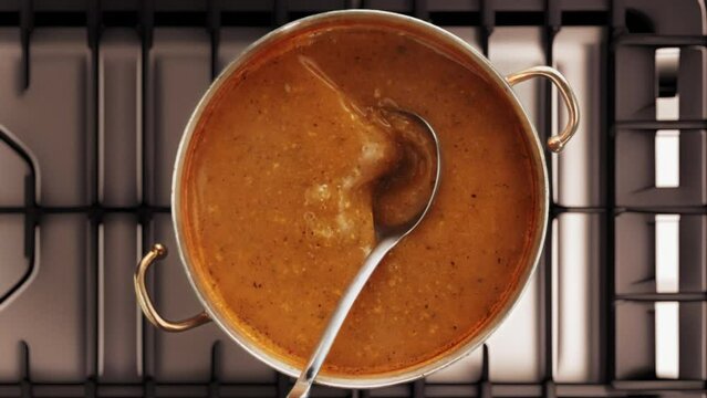 stirring a soup with a ladle