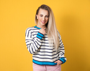 Pretty girl looks to camera, isolated on yellow background. Portrait of happy young woman Female Person with smiling expression