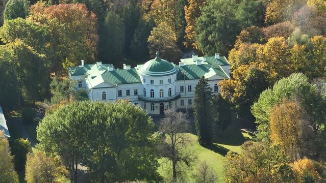 Drone shot over Baisogalos Manor in Baisogala, Lithuania with wood trees in the summer