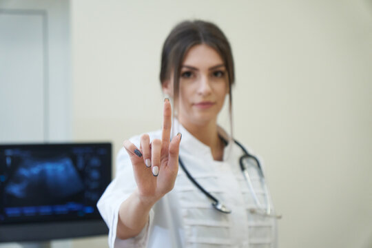 Confident female doctor pointing with her finger.
Doctor hand touch screen, copy space on white background.