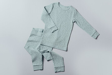 Blue pajamas for children on grey background. Pants and top for baby. Top view, copy space. Flat lay