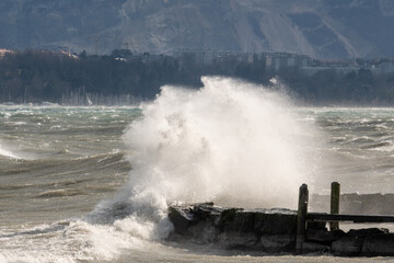 Fototapeta na wymiar les embruns de la grosse vague sur la jetèe, vent fort lac Léman