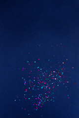 Colorful of confetti on blue background. Brilliant colored sequins. Holiday greeting card. Happy holidays. Minimal, flat lay, copy space. Mockup	